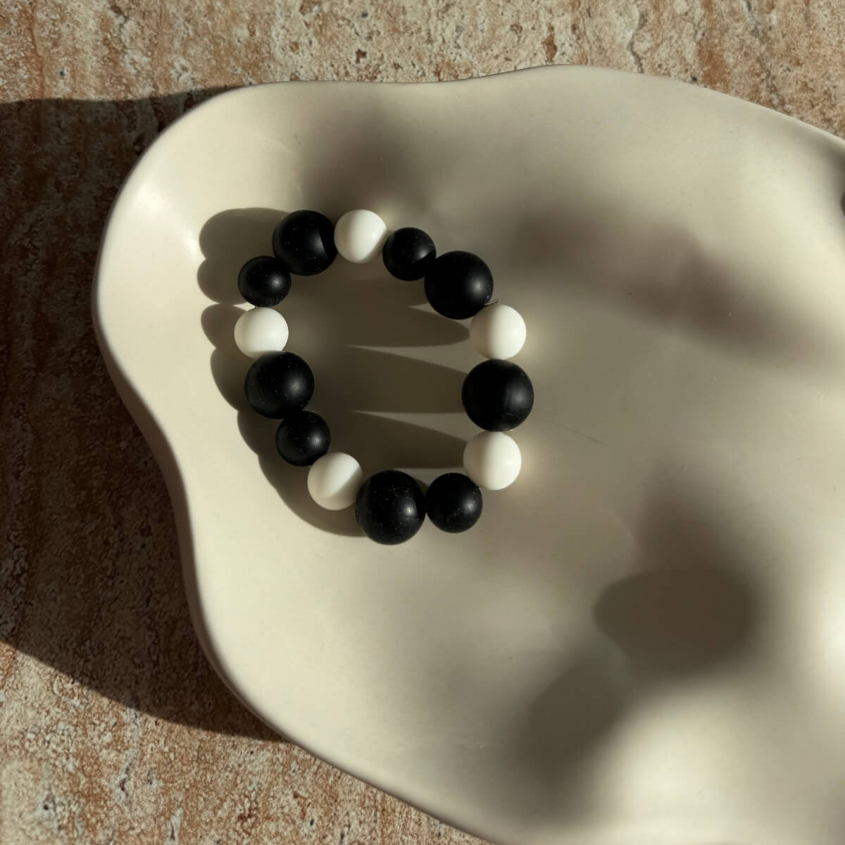 „Nahaufnahme des Midnight Frost Armbands in einer dekorativen Schale.“