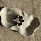 „Komplettes Midnight Frost Armband liegend in einer cremefarbenen Schmuckschale.“