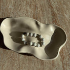 Komplettes Pearl Whisper Armband in einer Schale, elegante Perlen und Herzdetails sichtbar.