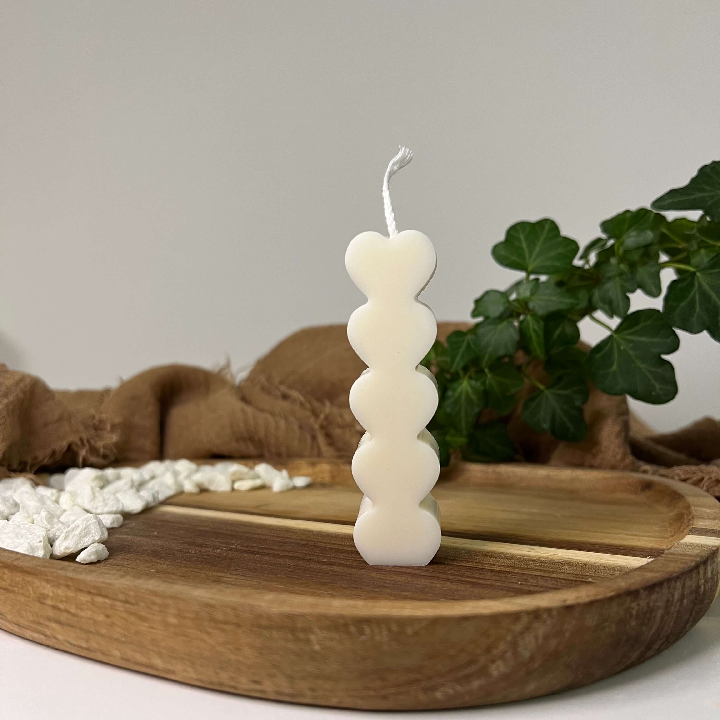 Hier sieht man unsere Radiant Love Tower Kerze. Sie ist perfekt als Dekoration geeignet mit ihrem Herzdesign. Sie ist elegant und ästhetisch. In weiß.