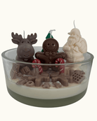 Handgegossene Weihnachtskerze in runder Schale auf einem Holztisch, mit weißem Schneewachs und festlicher Candy-Deko.