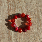 Rotes Bubble-Armband Strawberry Sparkle auf hellem Tisch arrangiert – handgefertigter Schmuck von Sym Aesthetics.