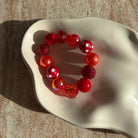 Nahaufnahme vom Strawberry Sparkle Armband in einer Schale, glänzende rote Perlen und Polka Dots.