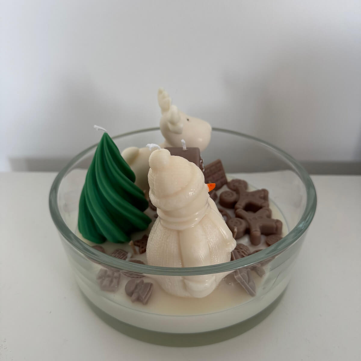 Obenansicht der festlichen Schalenkerze mit bunten Süßigkeiten, Schokolade und winterlicher Märchenlandschaft.