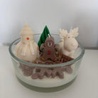 Sweet Winter Wonderland Kerze von der Seite, mit Schneemann, Elch und Lebkuchenmann auf einem schneeweißen Wachsboden.