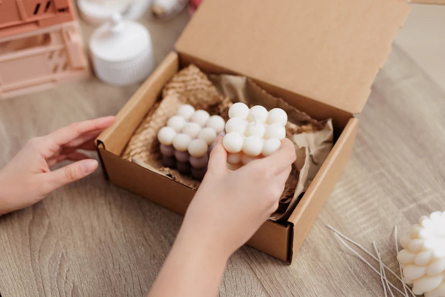Auf diesem Bild sind unsere handgefertigten Duftkerzen zusehen. Sie werden gerade als Geschenk-Set verpackt. Die Kerzen sind für jeden Raum geeignet und umweltfreundlich. Die Kerzen sind mit verschiedenen Düften erhältlich und sind perfekt als Dekoration geeignet. Auch kann man sie als Geschenk für Weihnachten oder Ostern benutzen.