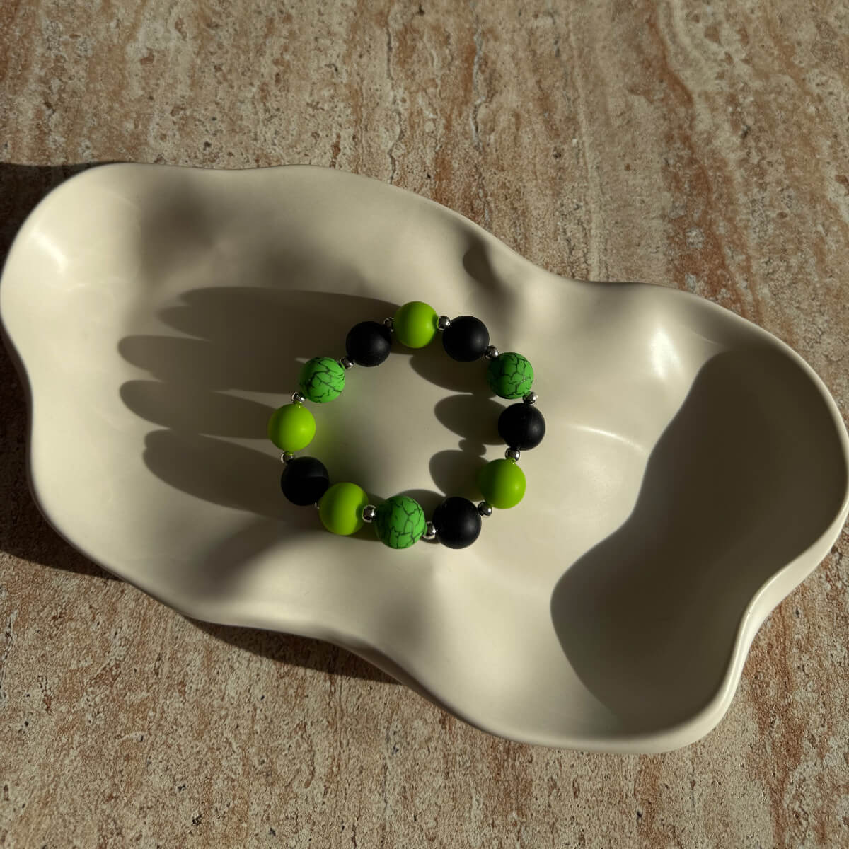 Toxic Orbit Armband komplett in einer Schale arrangiert, neon-grün und schwarz.